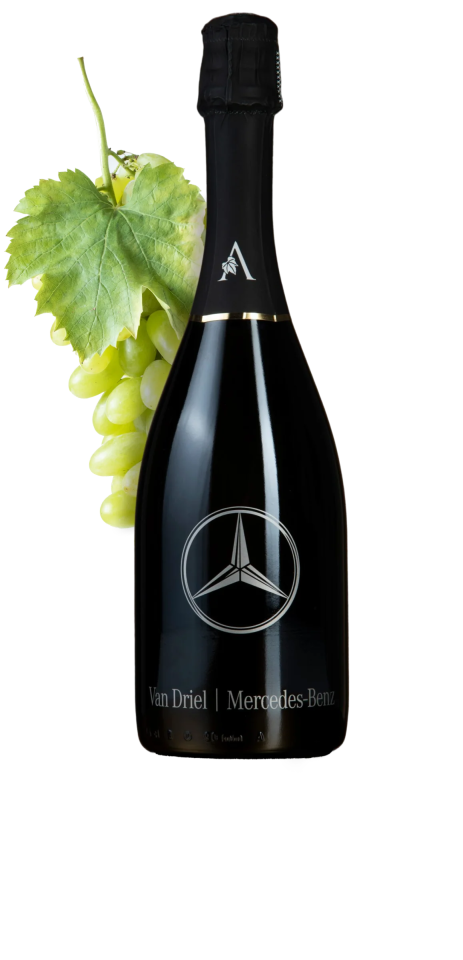 Zwarte Mercedes-Benz wijnfles met druiventros op de achtergrond.